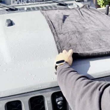 Person using DARCSUD HydroLoop microfiber drying towel to wipe water from Jeep hood
